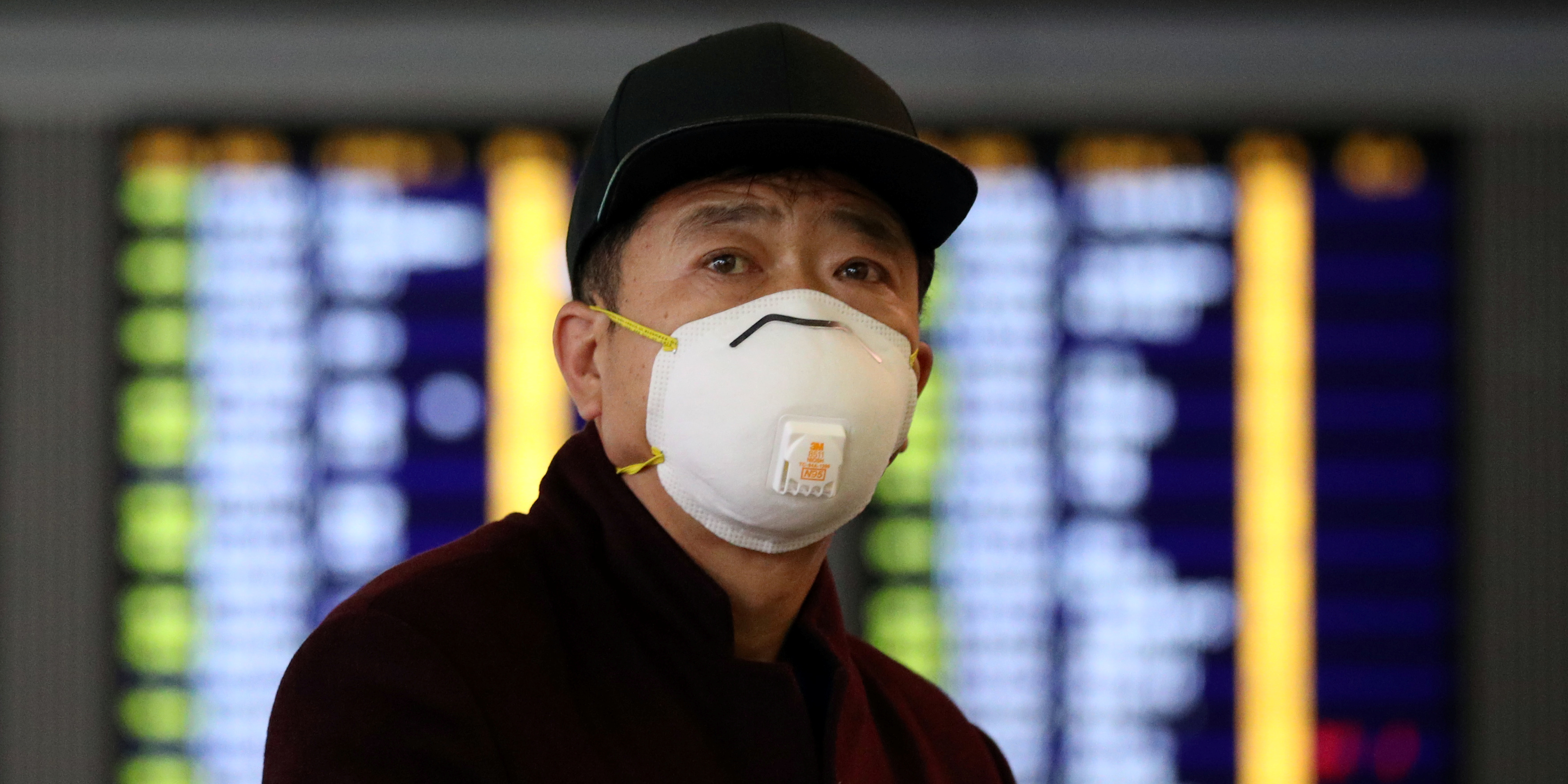 coronavirus-covid-19-un-passager-porte-un-masque-tandis-qu-il-marche-dans-l-aeroport-international-de-hong-kong-le-7-fevrier-2020