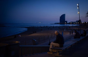 ep un hombre sentado en un banco delante de la playa y el hotel w barcelona en barcelona catalunya