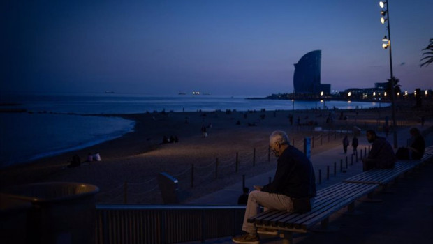 ep un hombre sentado en un banco delante de la playa y el hotel w barcelona en barcelona catalunya