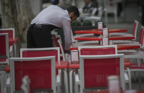 ep un camarero limpia las mesas de un bar en sevilla