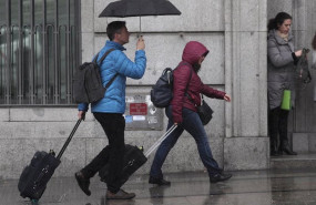 ep dos turistas se refugian de la lluvia con paraguas en madrid espana a 5 de marzo de 2020
