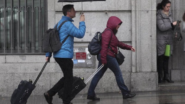 ep dos turistas se refugian de la lluvia con paraguas en madrid espana a 5 de marzo de 2020