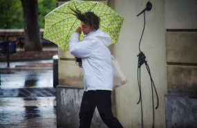 ep una mujer camina por la calle sujetando su paraguas movido por el viento durante el temporal de