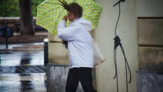 ep una mujer camina por la calle sujetando su paraguas movido por el viento durante el temporal de