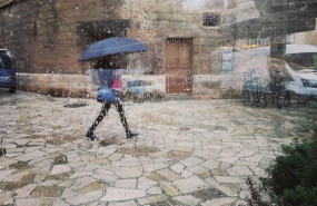 ep una mujer pasea por el centro de palma con un paraguas vista a traves de un cristal con gotas de