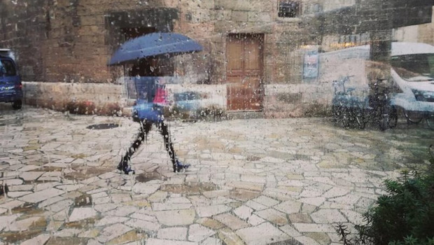 ep una mujer pasea por el centro de palma con un paraguas vista a traves de un cristal con gotas de