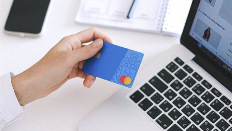 ep una persona utilizando su tarjeta de credito para realizar compras online con un ordenador