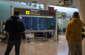 ep archivo   varias personas observan un panel de llegadas en el aeropuerto de barcelona en una