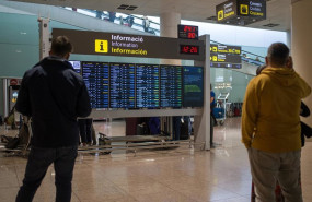 ep archivo   varias personas observan un panel de llegadas en el aeropuerto de barcelona en una