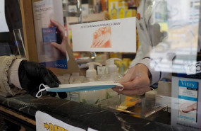 ep una persona coge una mascarilla que le da una trabajadora de una farmacia de vitoria durante el