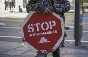 ep archivo   una persona sujeta un cartel de stop desnonamients stop desahucios