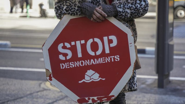 ep archivo   una persona sujeta un cartel de stop desnonamients stop desahucios