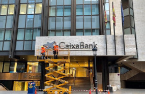 ep operarios colocan el logo de caixabank en el edificio que albergaba la sede de bankia en valncia