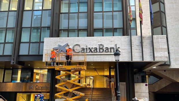 ep operarios colocan el logo de caixabank en el edificio que albergaba la sede de bankia en valncia