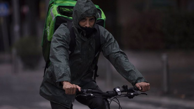 Un rider (repartidor) trabaja bajo la lluvia protegido con un impermeable. En Sevilla (Andalucía, España), a 04 de diciembre de 2020. | María José López - Europa Press - Archivo ep un rider repartidor trabaja bajo la lluvia protegido con un impermeable en sevilla andalucia