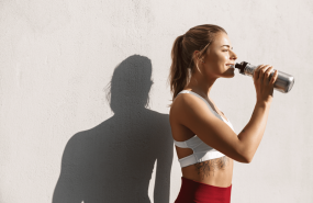 woman takes a break from her run by taking a drink from a water bottle 2 edited woman takes a break from her run by taking a drink from a water bottle 2 edited