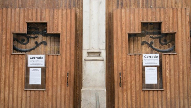 ep cruces en la puerta de una iglesia con el cartel de cerrado temporalmente