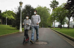 ep un nino circula con un patinete junto a un adulto en el primer dia en el que los menores de 14