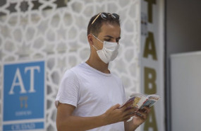 ep un turista lee una guia mientras pasea por el casco historico de sevilla