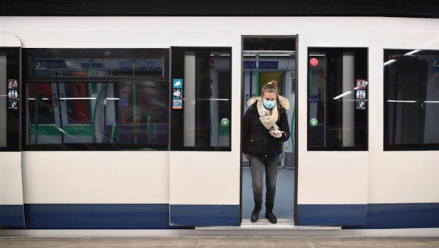 ep una mujer protegida con mascarilla se baja de uno de los metros de la capital en un anden con