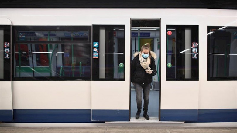 ep una mujer protegida con mascarilla se baja de uno de los metros de la capital en un anden con