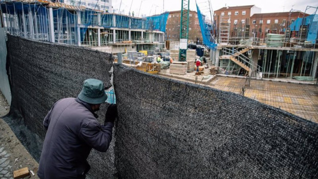 ep archivo   un hombre mira por el agujero de una lona de una obra en construccion