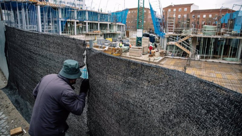 Archivo - Un hombre mira por el agujero de una lona de una obra en construcción | Carlos Luján - Europa Press - Archivo ep archivo un hombre mira por el agujero de una lona de una obra en construccion