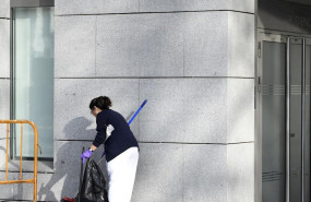 ep una trabajadora de la lipieza barre la puerta pricipal de la sede de la audiencia nacional de