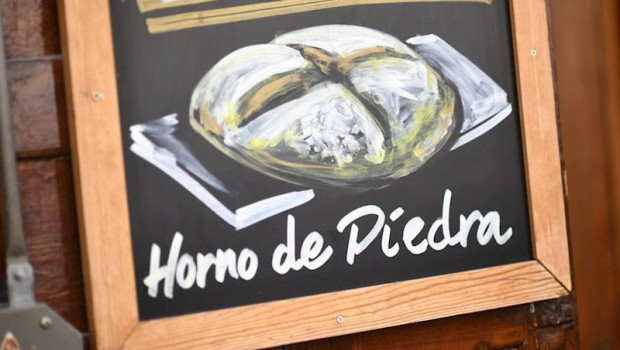 ep una pizarra con un dibujo de una hogaza de pan en la que se lee horno de piedra
