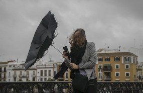 ep una racha de viento desbarata el paraguas de una viandante mientras camina por el puente de