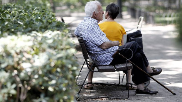 ep archivo   un pensionista descansa en un banco de un parque de madrid junto a una mujer mas joven
