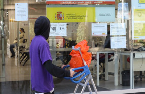 ep un joven pasa delante de una oficina de empleo