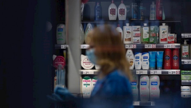 ep una mujer protegida con mascarilla y guantes trabaja en una tienda