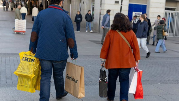 ep archivo   dos personas llevando varias bolsas de compra de distintos comercios