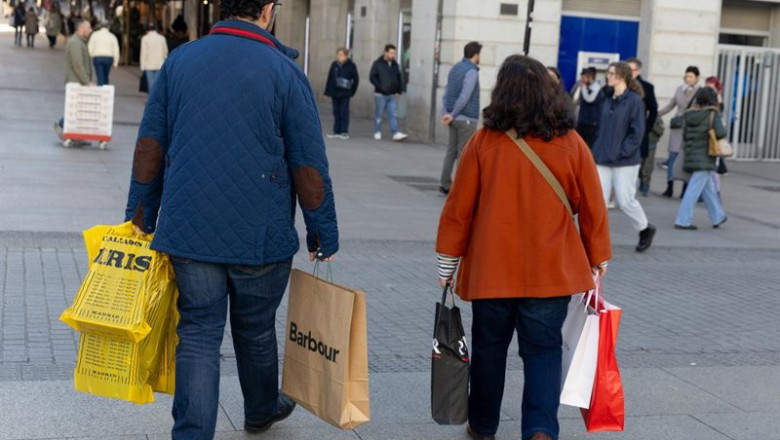 ep archivo   dos personas llevando varias bolsas de compra de distintos comercios