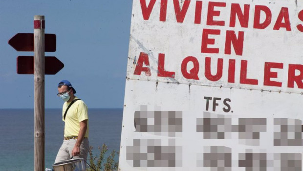 ep un hombre camina junto a un cartel de viviendas en alquiler en a marina