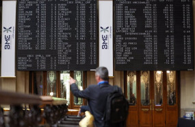 ep un hombre senala los paneles de valores del ibex 35 en el palacio de la bolsa de madrid