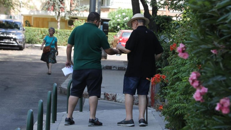 Un hombre le da una botella de agua a un anciano, mientras pasean por una calle de Madrid. | Marta Fernández Jara - Europa Press ep un hombredabotellaaguaun anciano mientras paseanuna callemadrid