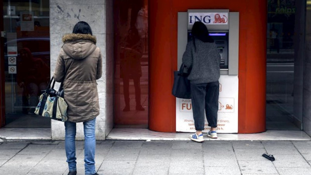 ep una mujer espera su turno frente a un cajero de ing