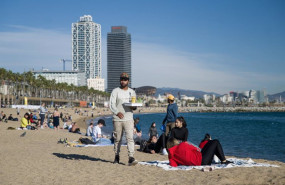 ep archivo   un camarero lleva bebidas a las personas que disfrutan en la playa de la barceloneta