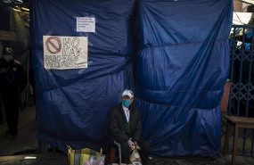 ep un vendedor ambulante ante la entrada de un mercadillo cerrado por el coronavirus en bolivia