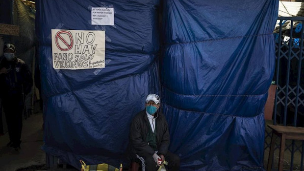 ep un vendedor ambulante ante la entrada de un mercadillo cerrado por el coronavirus en bolivia