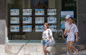 ep archivo   varias personas pasan junto a los anuncios de viviendas en venta en una inmobiliaria