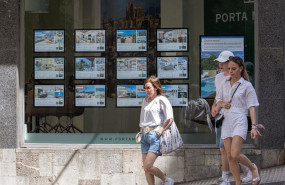 ep archivo   varias personas pasan junto a los anuncios de viviendas en venta en una inmobiliaria