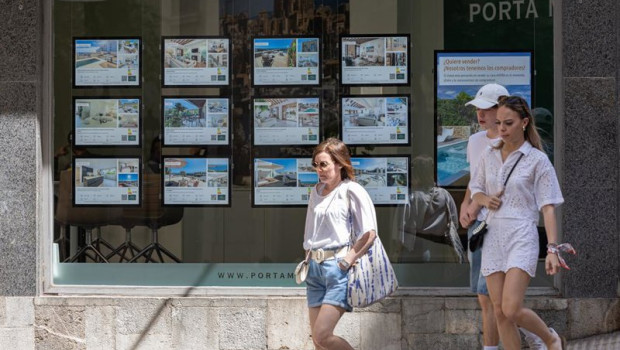 ep archivo   varias personas pasan junto a los anuncios de viviendas en venta en una inmobiliaria