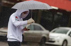 ep transeuntes protegidos con mascarilla y un paraguas caminan por las calles de la capital un dia