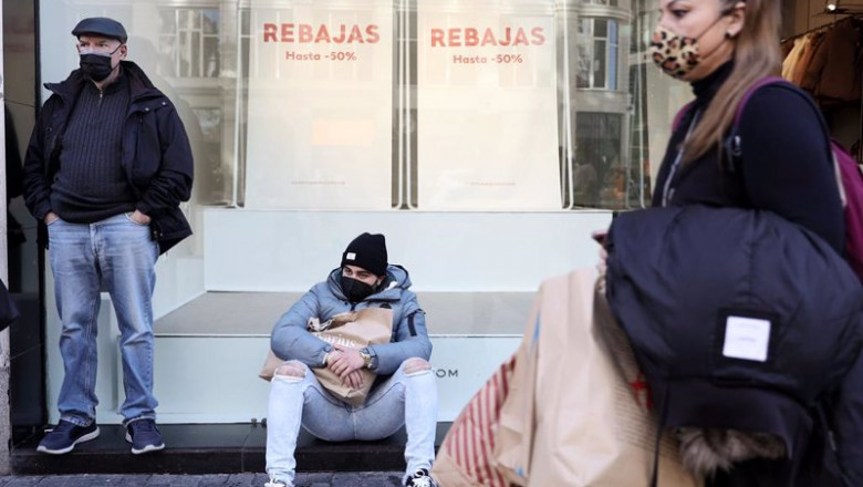 ep varias personas delante del escaparate de una tienda con descuentos de hasta el 50 a 7 de enero