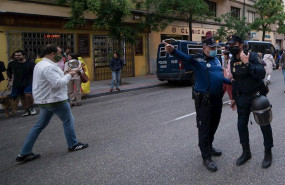ep un policia municipal hace indicaciones a un policia nacional mientras varias personas se