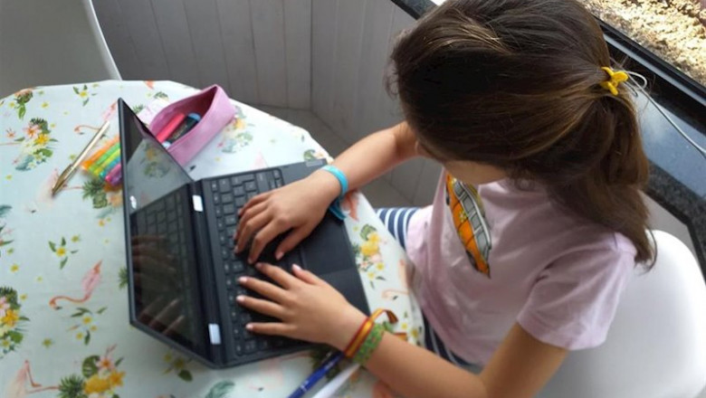 ep una nina haciendo deberes en casa con el ordenador portatil