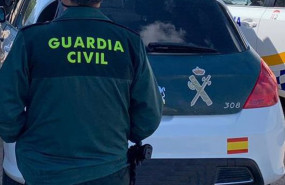 ep archivo   un agente de la guardia civil de espaldas y junto a un vehiculo oficial del cuerpo